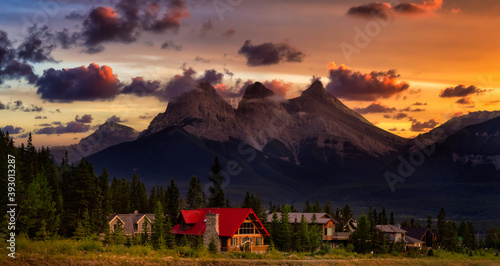 Beautiful Panoramic view of Residential Homes with Canadian Rocky Mountains in the background. Colorful Dramatic Sunset. Taken in Canmore, Alberta, Canada.