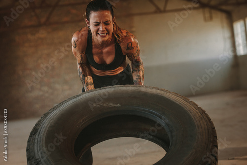 Tough woman doing tire flip workout