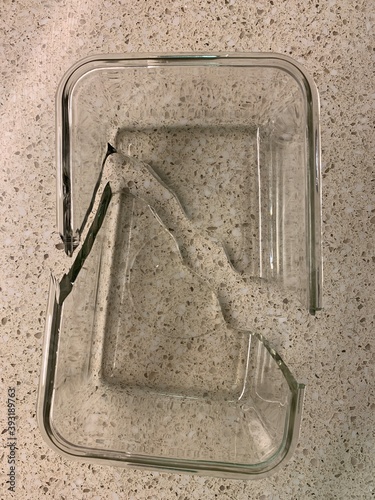 A clear pyrex dish is broken in 2 pieces.