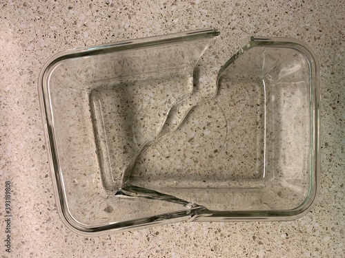 A clear pyrex dish is broken in 2 pieces.