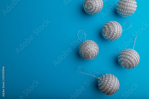 Christmas or New Year composition. Decorations, silver balls, on a blue background. Top view, copy space.