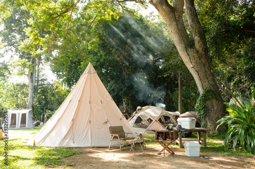 A large white traditional teepee tent with luxurious glamping interiorwith desk and chairs in forest,holiday/vacation,Camping