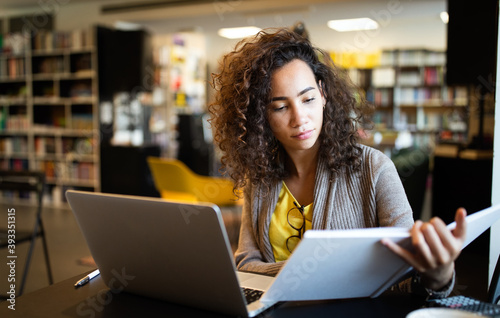 Young beautiful student girl working, learning in college library