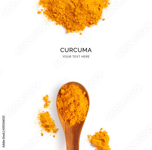 Creative layout made of turmeric powder and wood spoon on a white background. Top view. 