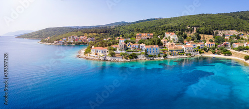 Panoramic aerial view to the beautiful village of Fiskardo on the island of Kefalonia, Greece, with colorful, red roofed houses by the turquoise sea