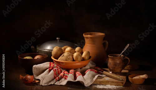 Still life with old ceramic and raw potato dishes