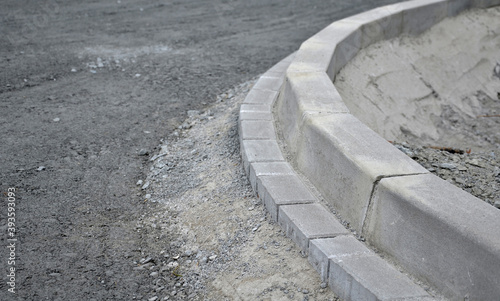 installation of concrete curb into concrete. in the space of the road, which so far has only a concrete base before laying the asphalt layer and rolling.