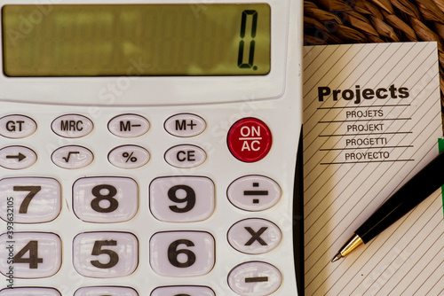 Una calculadora junto a una hoja de proyecto y un bolígrafo.