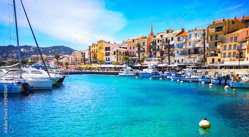 Eau turquoise dans le port de Calvi en Corse entouré de ses immeubles colorés.