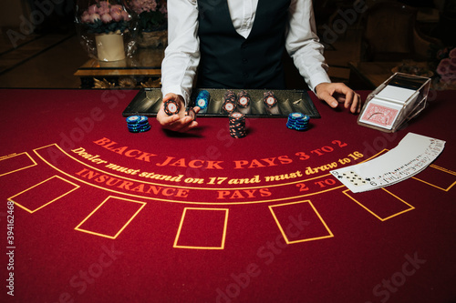 Croupier hands dealing cards on t blackjack poker table, gambling table with cards and chips