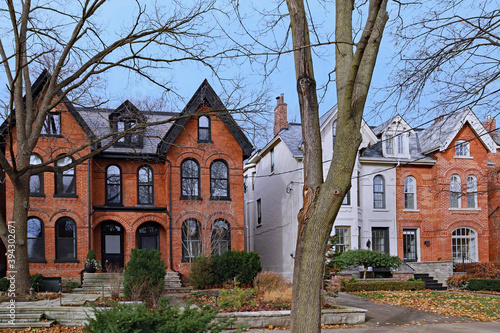 Street with large old brick semidetached houses with gables