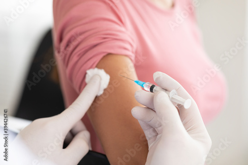 Male doctor doing vaccination to young woman