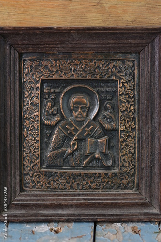 close-up religious image of metal in a frame on a wooden background