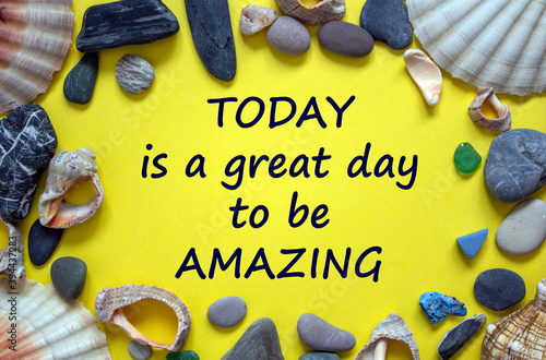 Words 'today is a great day to be amazing' on a beautiful yellow background. Sea stones and seashells. Inspirational and motivational concept.