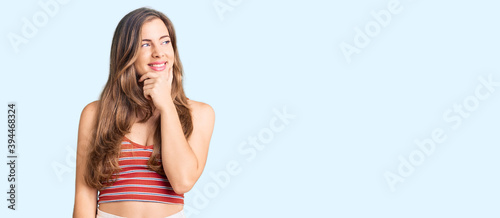 Beautiful caucasian young woman wearing casual clothes with hand on chin thinking about question, pensive expression. smiling with thoughtful face. doubt concept.