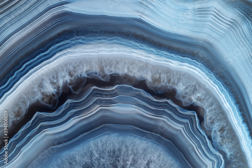 Full-screen close-up texture of translucent white-blue agate with a concentric pattern and ghostly quartz crystals