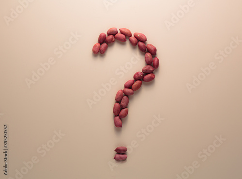 Question mark sign made of peanuts. Top view. Nutrition and food choices. Doubts about the product