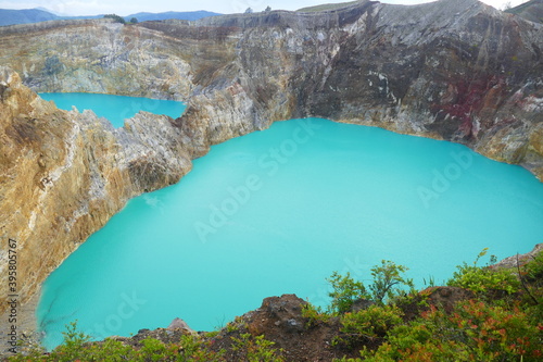 photo picture of a beautiful amazing delightful volcanic multicolor lake in the crater of a volcano Lake Kelimutu National Park Island of Flores against the backdrop of a wonderful skyline.