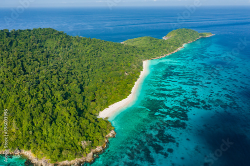 Aerial view of a deserted beach on a rugged tropical island surrounded by coral reef (Koh Tachai)
