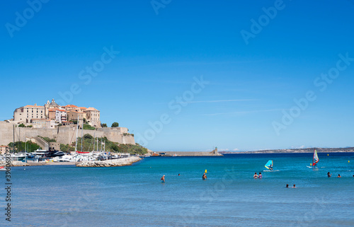 Calvi beach in summer view of the turquoise blue sea with people