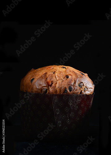 artisanal panettone typical from Milano area on black background whit cutting light