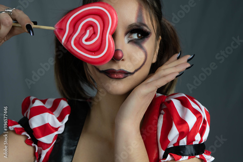 Fun photo session with a young arlekin woman dressed in red, black and white. Nice images for carnival days or for costume and makeup businesses.