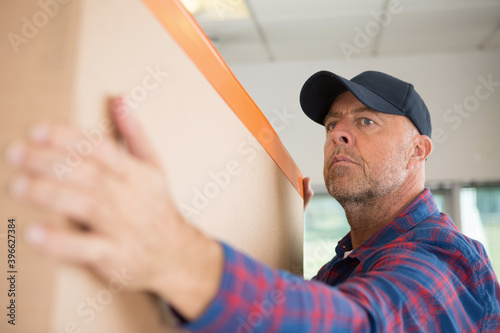 senior man carrying a large cardboard box