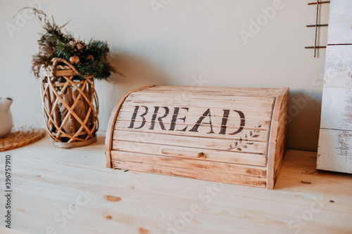 Christmas decorations. Bascet with fir branches and breadbox on the wooden table. Festive table decorations.