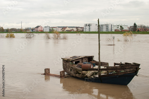 Old wooden boat on a flooded river Sava, Zagreb, Croatia with buildings in the background