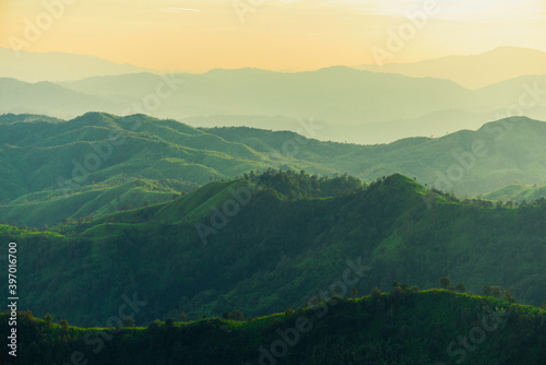 beautiful huge green mountain range shillouete in sunset time with fog
