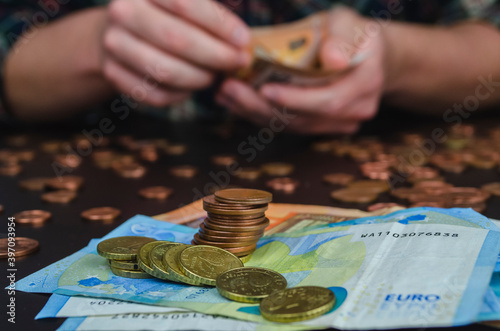 manos de hombre contando dinero, monedas y billetes