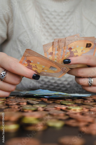 manos de mujer contando dinero, monedas y billetes