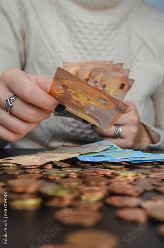 manos de mujer contando dinero, monedas y billetes