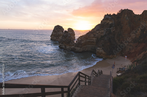 Praia da Boneca do Camilo Lagos Portugal staircase stairs stairway to the beach water ocean Atlantic rock formations hills morning sunrise violet sky
