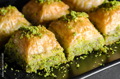 Traditional turkish dessert antep baklava with pistachio on rustic table, ramadan or holiday desserts concept