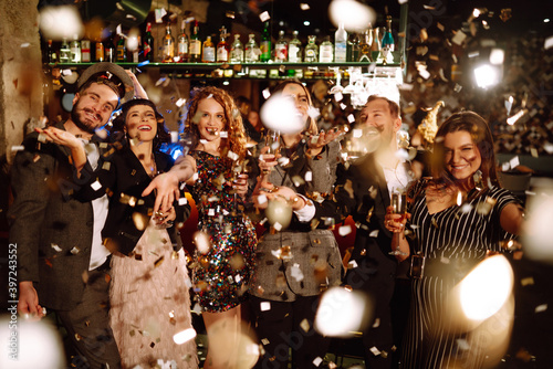 Confetti party. Have fun together. Group of happy people throwing confetti while enjoying party. Holiday, celebration, drink, birthday concept.