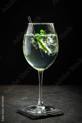 Hugo cocktail with champagne, lime, mint and Melissa syrup on a black background, aperitif drink