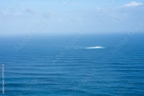 Landscape of ocean with whirlpool seen in distance