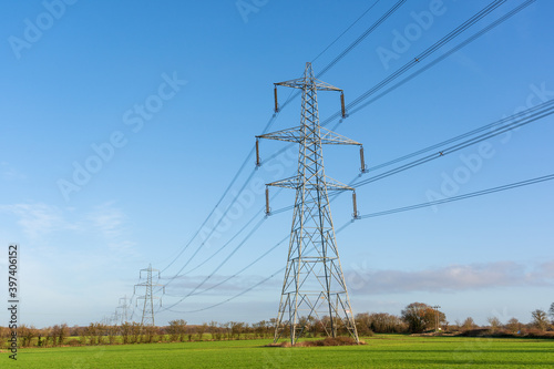 Electricity pylons in a field with blue sky. Bishop's Stortford, Hertfordshire. UK