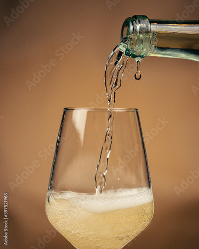 Pooring lambrusco white wine in glass