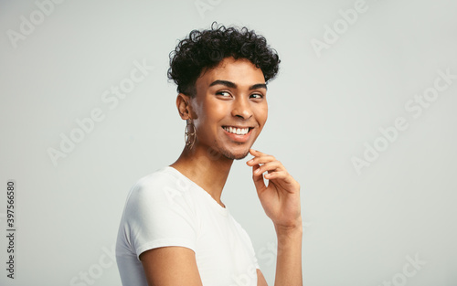 Smiling androgynous man looking away