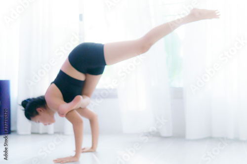 Young Asian woman practice yoga in bedroom in the morning
