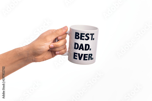 Hand of caucasian young man holding cup of coffee with best dad ever message over isolated white background