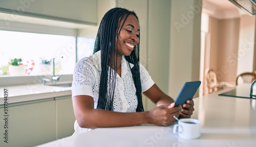 Young african american woman smiling happy using touchpad at home