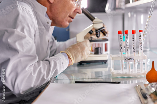 scientist, researcher conducts research or experiment by using microscope. senior professor chemist at work place in laboratory, biology microbiology concept