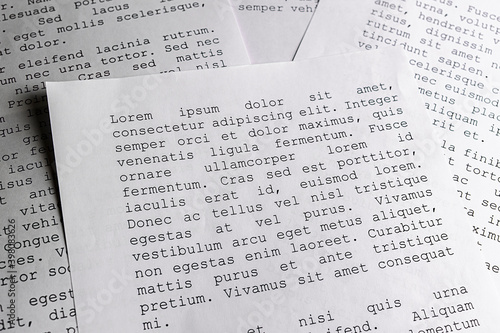 lorem ipsum dolor sit amet concept. selective focus photo of paper sheets with publishing and graphic design placeholder text on them.