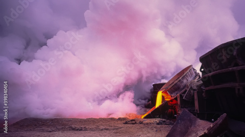 clouds of steam formed during cooling with water during the discharge of hot incandescent blast furnace slag of metallurgical production, blurred background.