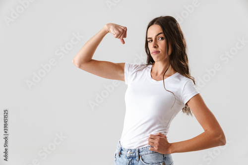 Pleased beautiful girl showing her bicep at camera
