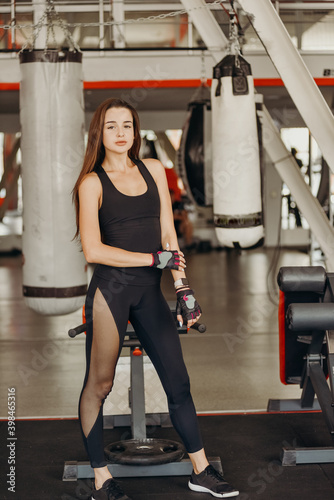 Portrait of beautiful young fit woman during training in the gym at the fitness center.
