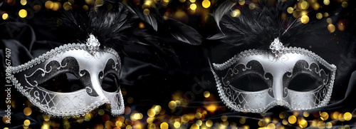 beautiful two venitian carnival masks on dark fabric and blur lights background